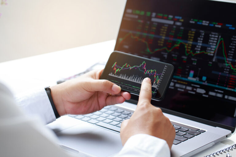 Close up businessman hand holding phone and analysis finance mar